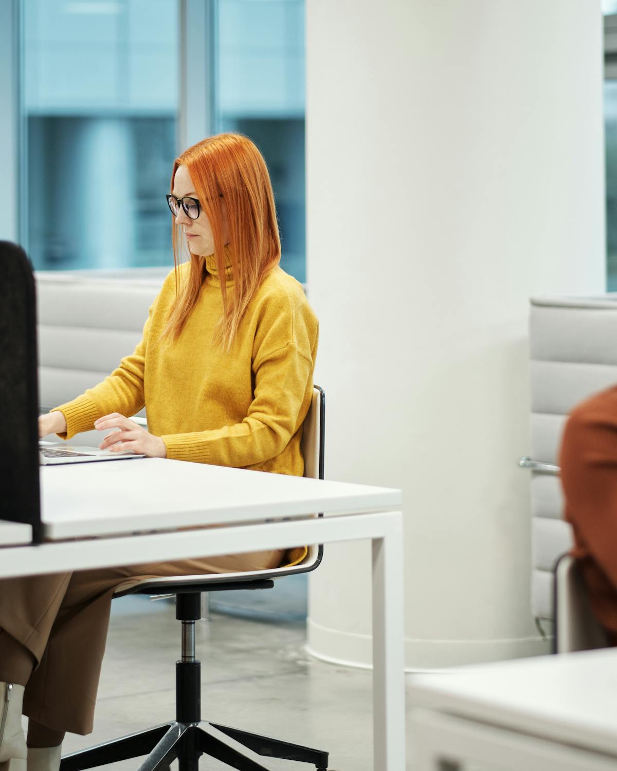 Customer support professional working in a modern office with mustard yellow accents